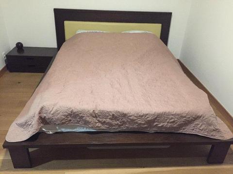 Drewniane łóżko i szafka nocna w nowoczesnym stylu
