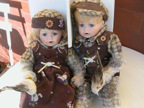 dwie lalki porcelanowe w kartonie na prezent